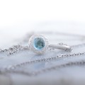 Minimalistyczna zawieszka z okrągłym niebieskim topazem w białym złocie pr. 585